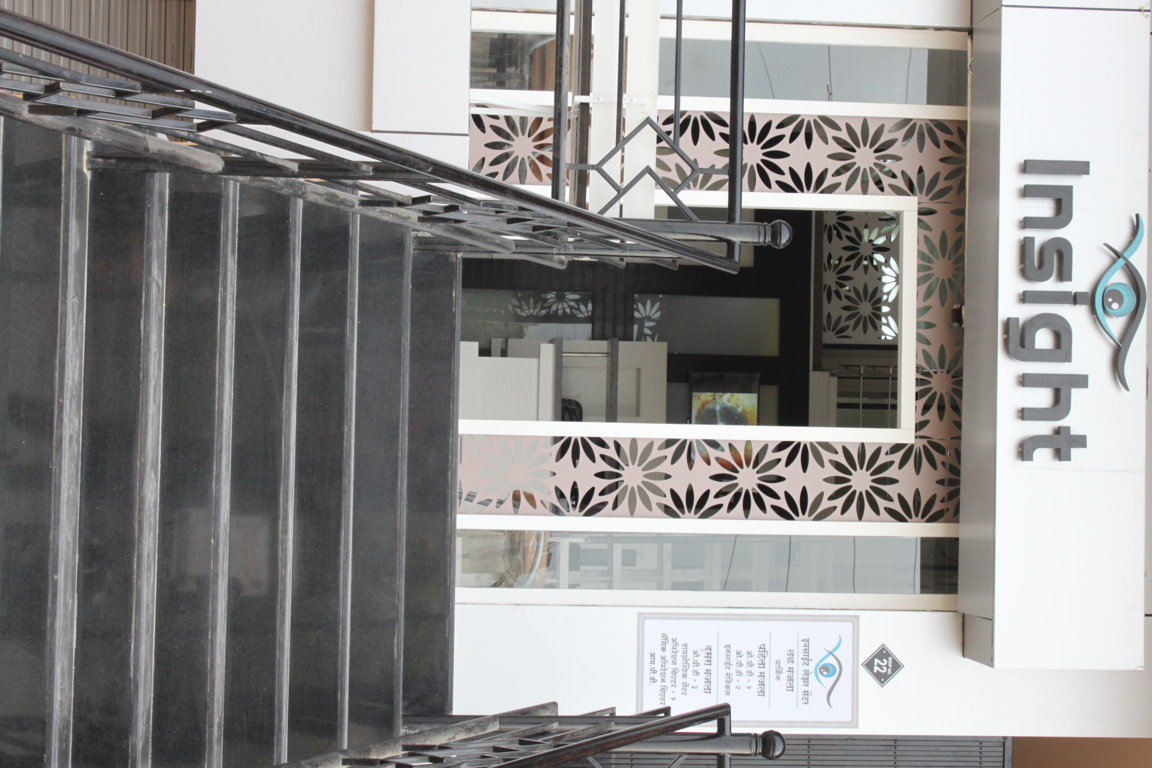 Stairwell rising from the street to the Insight Institute ophthalmology entrance, with the brand marquee visible at the landing above